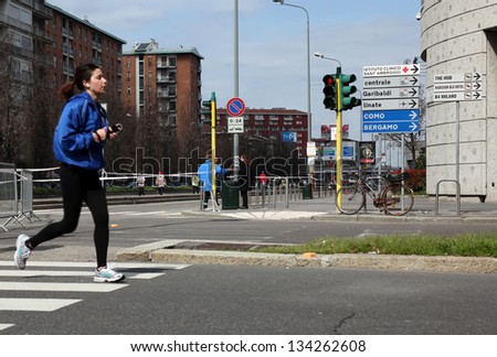 MILAN - APRIL 07: Woman running on the city streets during Milano City Marathon on April 07, 2013 in Milan, Italy.