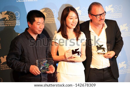 VENICE - SEPTEMBER 8: Wang Bing, Yoo Min-young and Frederic Fonteyne pose for photographers at 69th Venice Film Festival on September 8, 2012 in Venice, Italy.