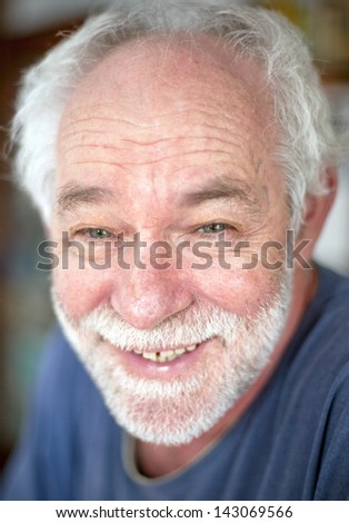Smiling caucasian man with blue eyes and white beard