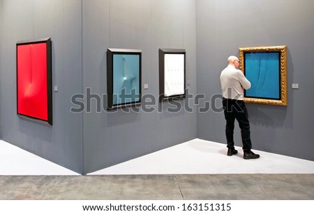 MILAN, ITALY - APRIL 08: Man looks at paintings galleries during MiArt, international exhibition of modern and contemporary art on April 08, 2011 in Milan, Italy