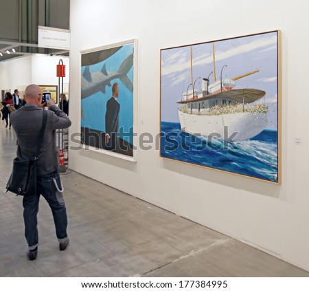 MILANO, ITALY - APRIL 07, 2013: A man looks at paintings gallery at MiArt, international exhibition of modern and contemporary art April 07, 2013 in Milan, Italy.