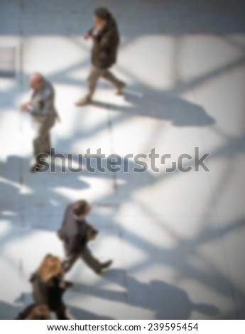 People walk, intentionally blurred post production.