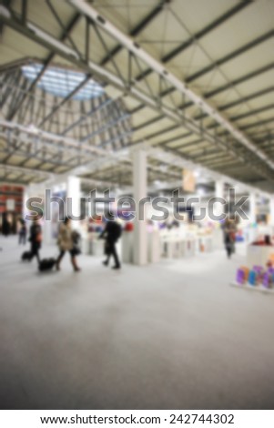 People walk at trade show. Intentionally blurred post production.