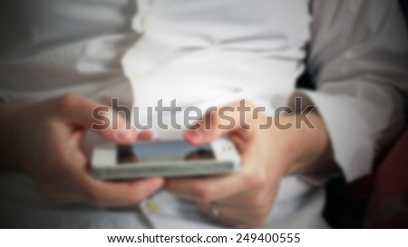 Man checks the agenda on his smart phone. Intentionally blurred post production background.