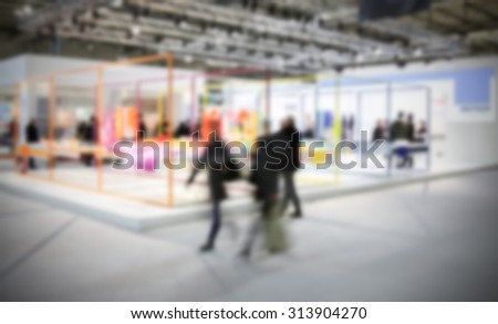 People walking during an event, intentionally blurred post production background.