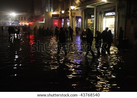 VENICE, ITALY - JAN. 01: Crowd dance in the water during New year\'s day party at San Marco square even with high tide arriving January 01, 2010 in Venice, Italy.
