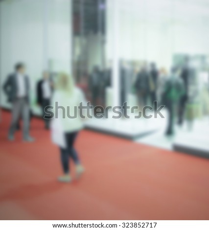 People visit a trade show, generic background. Intentionally blurred post production.