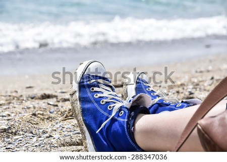 Blue shoes in sand by the beach