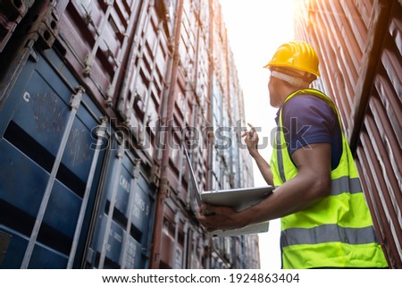 Professional industry worker of logistic concept.Engineer or foreman control loading Containers box from Cargo freight ship for import export,Engineer worker checking quantity of product in containers Zdjęcia stock © 
