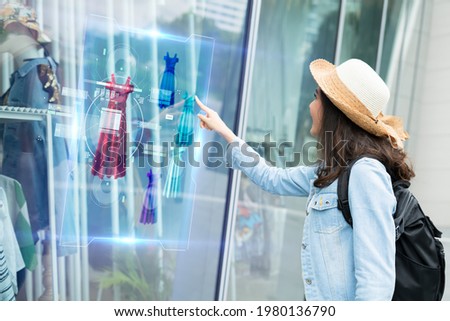 futuristic technology,smart retail online concept.Woman try to use  hologram display with virtual augmented reality in the shop or retail to choose select ,buy cloths and change a color of products