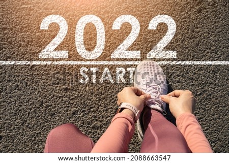 New year 2022 or straight forward concept.Word 2022 written on the road in the middle of asphalt road at sunset.Concept of planning and challenge,hope,new life change,business strategy,opportunity 