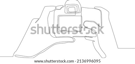Simple continuous line drawing Photograph's hands holding DSLR photo camera isolated on the background.  DSLR camera back side in hand. Scenes from the Studio. Vector Illustration.