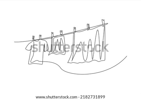 Continuous one line drawing clean clothes hanging on a rope. Laundry service concept. Single line draw design vector graphic illustration.