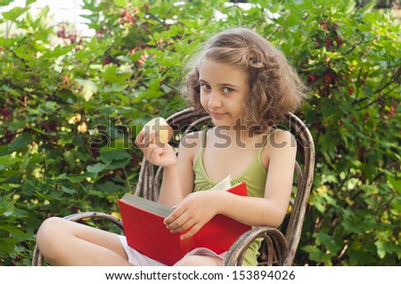 child reading a book in the garden