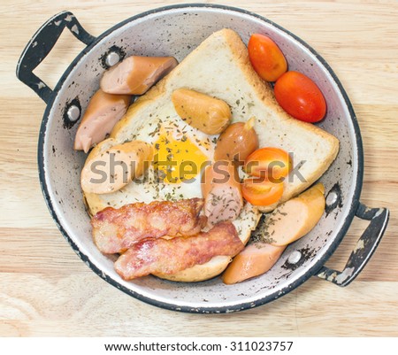 Ham and Egg. Bacon and Egg. Salted egg and sprinkled with black pepper. English breakfast. Grilled bacon, and bread in pan ready to serve