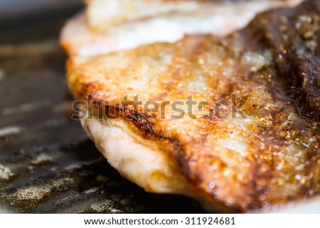 Selective focus the golden skin of salmon steaks in the iron pan