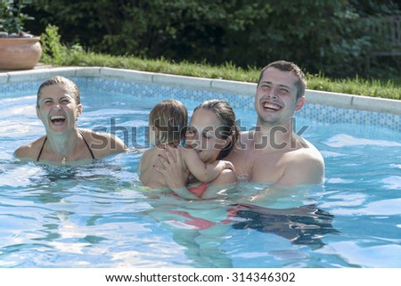 Family swimming and relaxing in a swimming pool