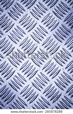 Blue colored Diamond plate also known as checker plate, tread plate, cross hatch kick plate and Durbar floor plate, closeup in portrait orientation.