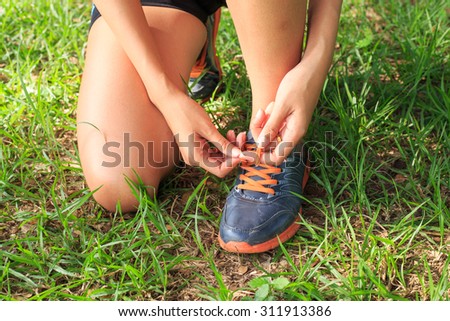 woman runner tie his shoes