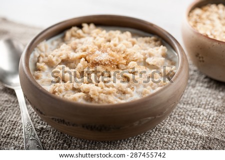 Traditional oatmeal breakfast bowl with milk and sugar