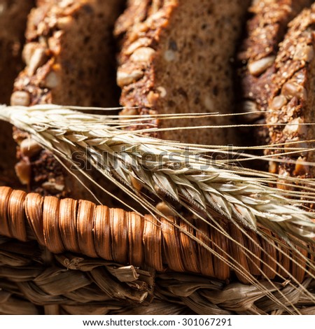 Sliced rye bread with seeds in the basket on a wooden table, close up