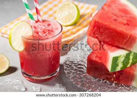 Glass of watermelon juice with ice and watermelon on the plate