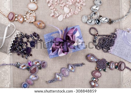Female jewelry and gift box on linen tablecloth, background