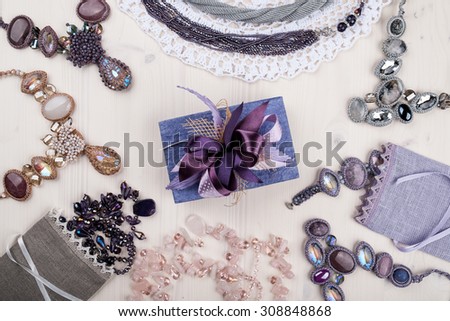 Female jewelry and gift box on light wooden background