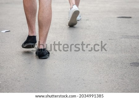 Selective blur on unrecognizable legs and feet of caucasian white male wearing flip flop slippers sandals with black socks. Flipflops and socks are a german stereotype considered as a faux pas. 

 ストックフォト © 