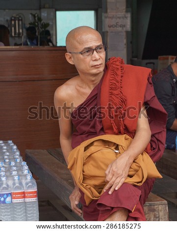 MANDALAY, MYANMAR - JUNE 1, 2015. An unidentified Burmese Buddhist monk in Mandalay, Myanmar. In 2012 an ongoing conflict started between Buddhists and Muslims in Myanmar.