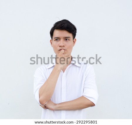 Portrait of young handsome man of Asian thinking and watching.