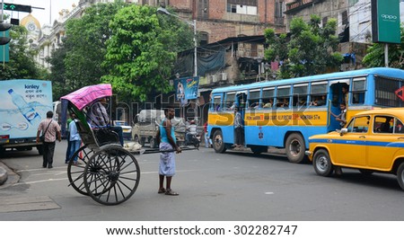 KOLKATA, INDIA - JUL 8, 2015. Rickshaw driver working in Kolkata, India. Rickshaws have been around for more than a century, but they could soon be a thing of the past.