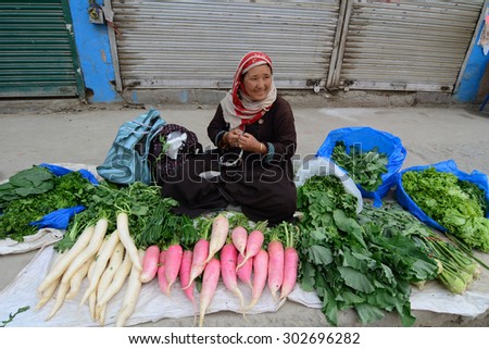 LADAKH, INDIA - JUL 22, 2015. Unidentified Ladakhi ladies selling fruit and vegetables by the side of the road in Leh market, Ladakh, India.