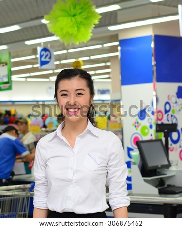 Positive sales assistant portrait in supermarket store in Asia.