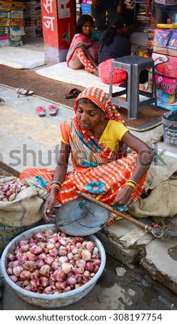 Bodhgaya, India - Jul 12, 2015. An Indian woman selling vegetables in a crowded market in Bodhgaya, India. Its a common practice in India to sell vegetables in open markets and streets.
