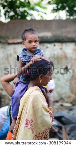 AGRA, INDIA - JUNE 27, 2015. Unidentified traditionally dressed mother and her son walking on the streets of Agra city, India.