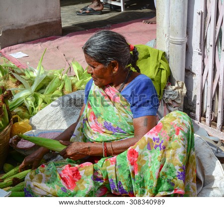 Bodhgaya, India - Jul 12, 2015. Unidentified woman selling vegetables in a crowded market in Bodhgaya, India. Its a common practice in India to sell vegetables in open markets and streets.
