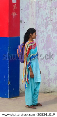 DELHI, INDIA - JUN 22, 2015. Indian woman on street wearing traditional sari in Delhi, India. Saris are wrapped around the body, 4 to 8 metres in length.