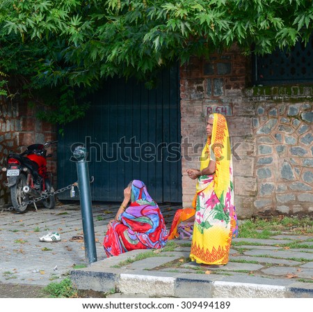 DELHI, INDIA - JUN 22, 2015. Indian women on street wearing traditional sari in Delhi, India. Saris are wrapped around the body, 4 to 8 metres in length.