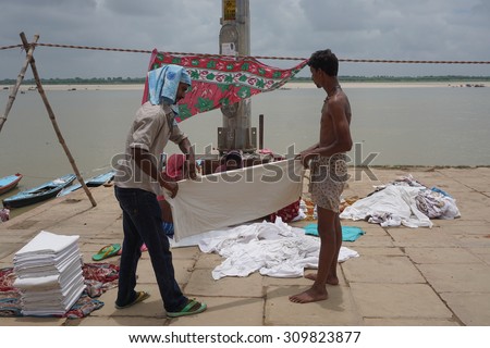 Varanasi, India - Jul 12, 2015. Indian people doing their daily activities by the River Ganga at the Assi Ghat, including drying their clothes. Ghats of Varanasi serves many purposes.