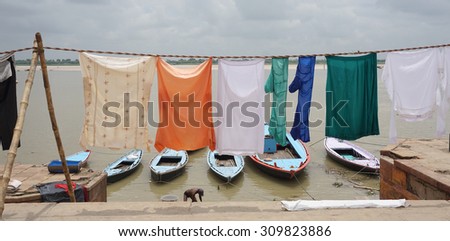 Varanasi, India - Jul 12, 2015. Many Indian people doing their daily activities by the River Ganga at the Assi Ghat, including drying their clothes. Ghats of Varanasi serves many purposes.