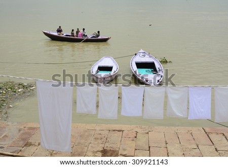 Varanasi, India - Jul 12, 2015. Local people doing their daily activities by the River Ganga at the Assi Ghat, including drying their clothes. Ghats of Varanasi serves many purposes.