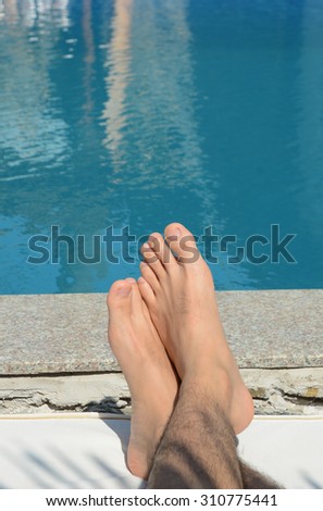 Asian man\'s feet in a swimming pool in Vietnam.