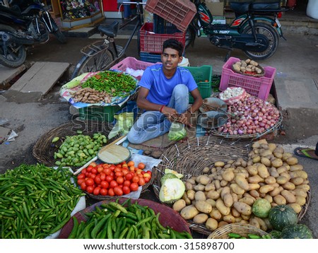 DELHI, INDIA - AUG 5, 2015. Unidentified men sell fresh vegetables from local market in Delhi, India. Street vendors are widely spread through out the city.