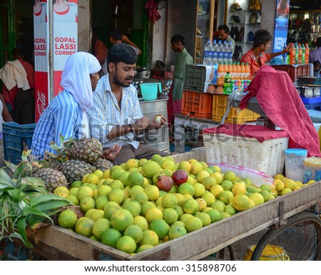 DELHI, INDIA - AUG 5, 2015. Unidentified men sell fresh fruits on the street in Delhi, India. Street vendors are widely spread through out the city.