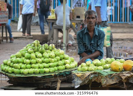 DELHI, INDIA - AUG 5, 2015. Unidentified men sell fruits from a stall in Delhi, India. Street vendors are widely spread through out the city.
