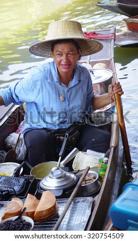 Bangkok, Thailand - May 22, 2015. A Thai woman selling traditional cake on the Damnoen Saduak floating market in Thailand. This is the most famous of the floating markets in Thailand.