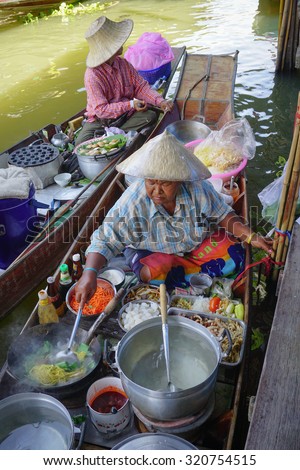 Bangkok, Thailand - May 22, 2015. Thai women cooking foods for sale on the Damnoen Saduak floating market in Thailand. This is the most famous of the floating markets in Thailand.