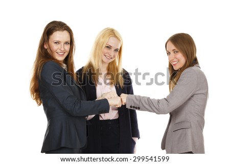 Three businesswomen putting their fists together in a \