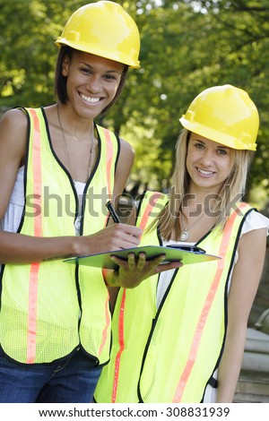 Two utility workers with clipboard smiling.